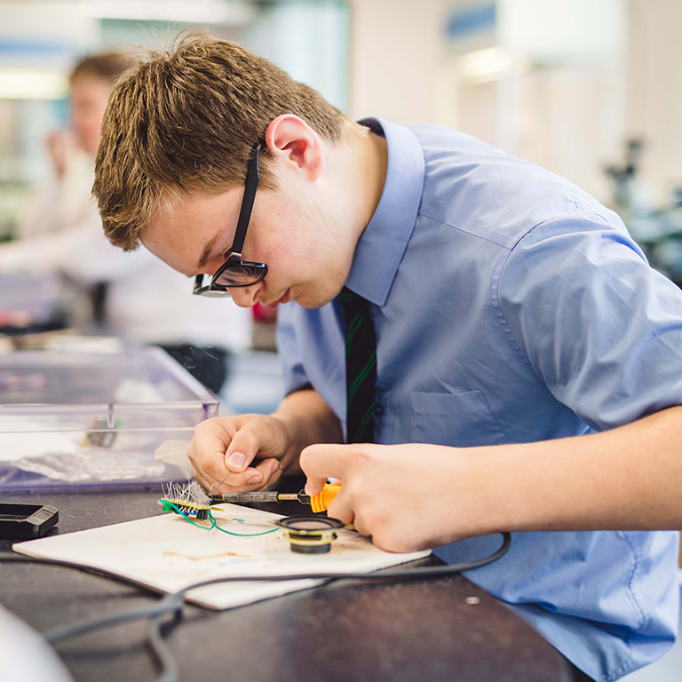 A Design and Technology student soldering his electronic prototype.
