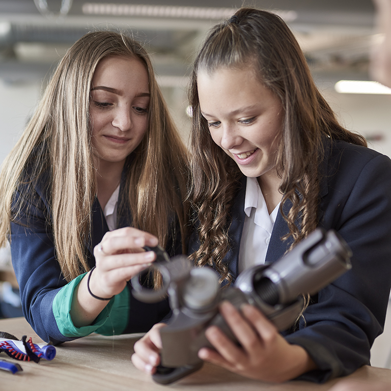 Two female school students disassembling a Dyson vacuum cleaner head - an activity from the James Dyson Foundation Engineering Box.