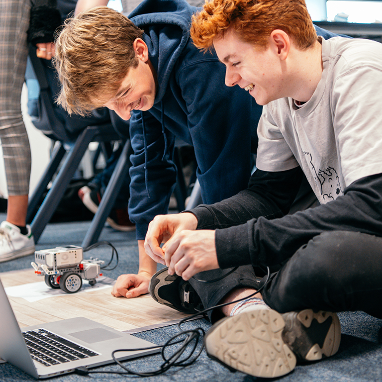 Two sixth form students programming a Lego Mindstorms robot in a James Dyson Foundation robotics workshop.
