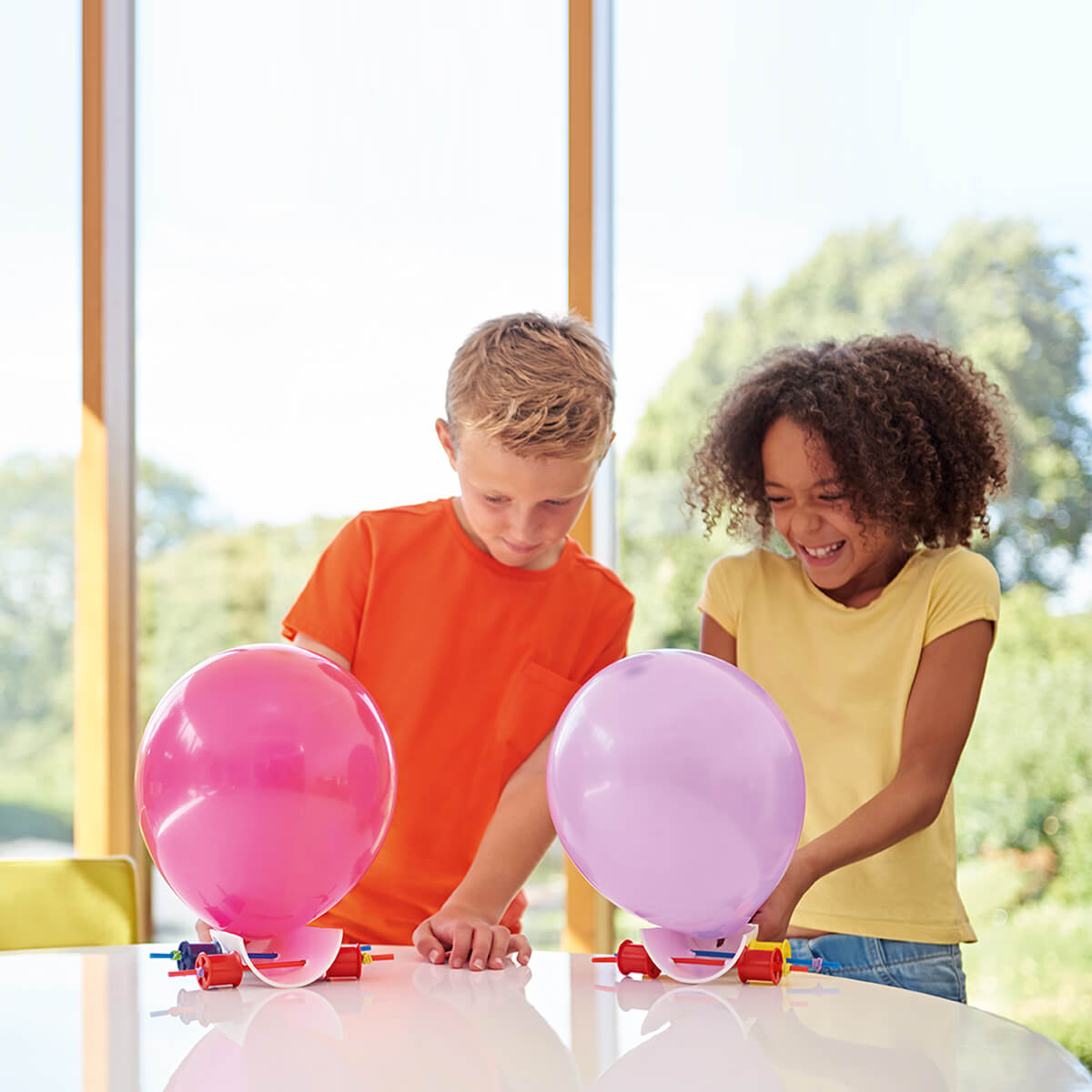 Image of two kids making balloon cars