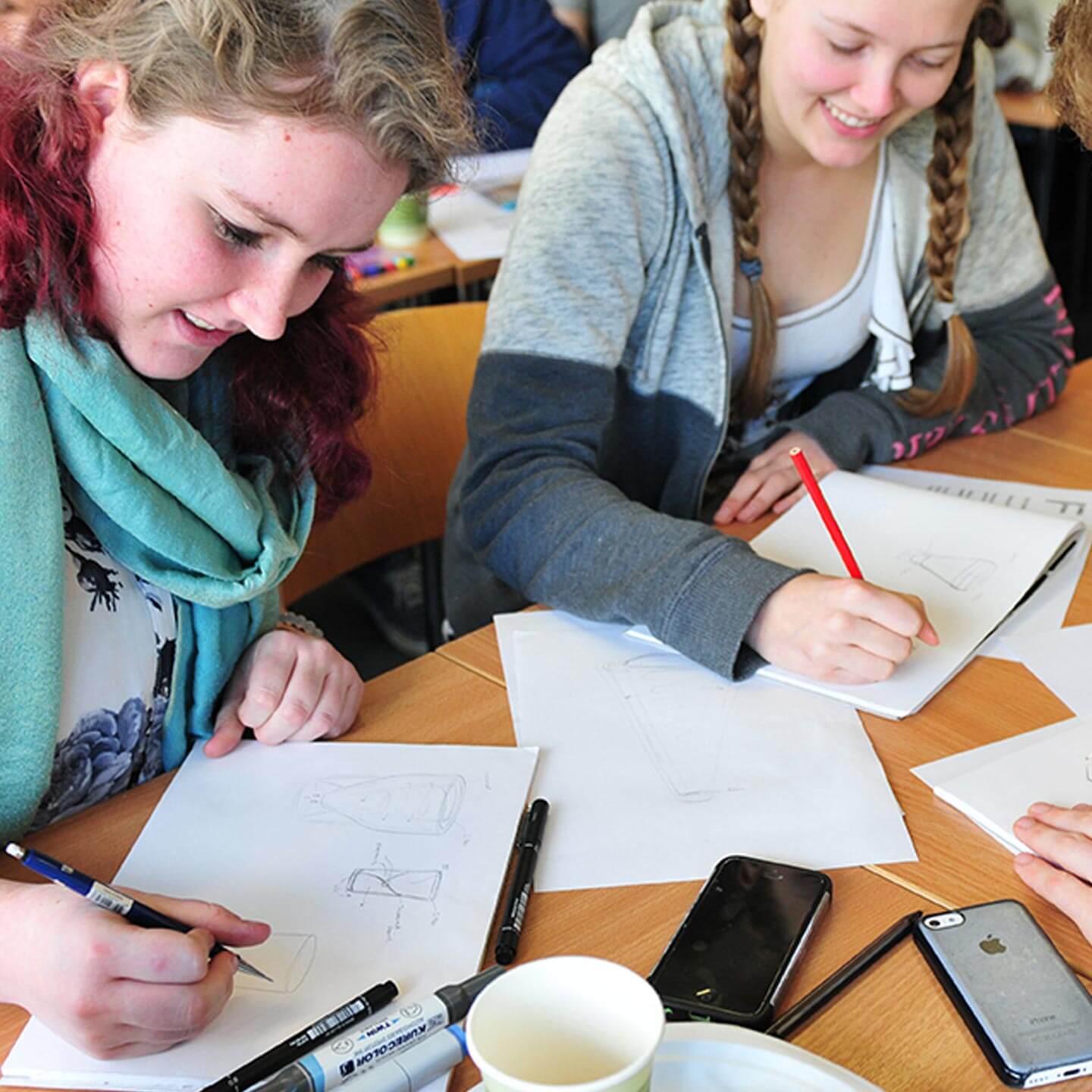 Two university students sketching their problem solving ideas in a James Dyson Foundation workshop.