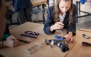 A student disassembling a vacuum cleaner machine head.