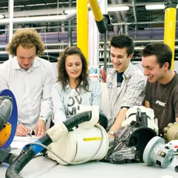 Four engineers working together to improve a prototype.
