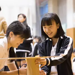 Two students using cardboard to build a prototype.