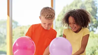 Two students building a balloon car.