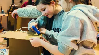 Two students building a prototype from cardboard.