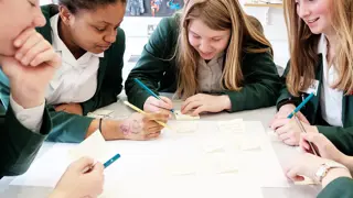 Four students working in a group to plan their invention in a prototyping workshop.