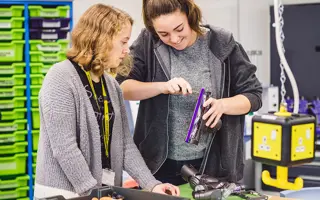 Two students disassembling a Dyson machine head.