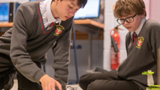 Two students programming Lego Mindstorms robots.