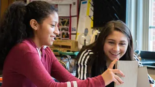 Two students building a prototype from cardboard.