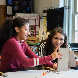 Two students building a prototype from cardboard.