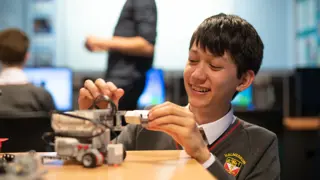 A student engaging with a Lego Mindstorms robot.