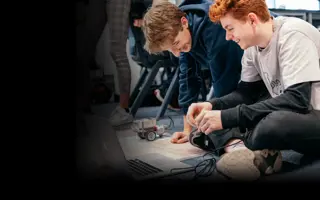 Two students programming Lego Mindstorms robots.