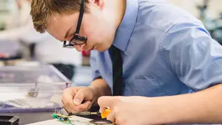 A student working on a circuit board.