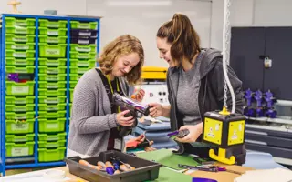 Two students disassembling a Dyson machine head.