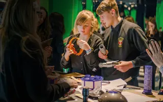 Two students building a prototype from Dyson machine parts and cardboard.
