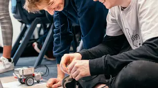 Two students coding Lego Mindstorms robots.