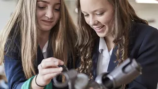 Two students disassembling a Dyson machine head.