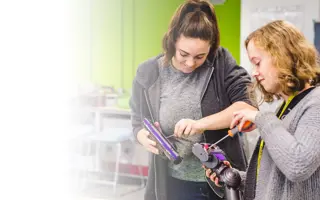 Two students disassembling a Dyson machine head.