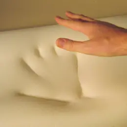 A close-up of a hand on a memory foam mattress.